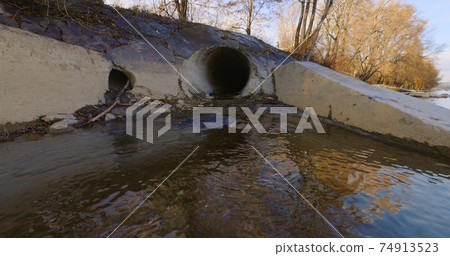 Large sewage tunnel with filth flowing out 74913523