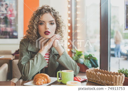Young beautiful woman sitting in city street cafe 74913753