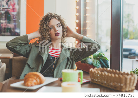 Elegant woman sitting in city street cafe 74913755