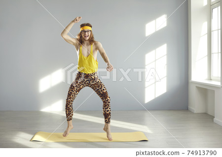 Funny skinny fitness nerd dancing, jumping and having fun during sports workout at home Funny skinny fitness nerd dancing, jumping and having fun during sports workout at home 74913790