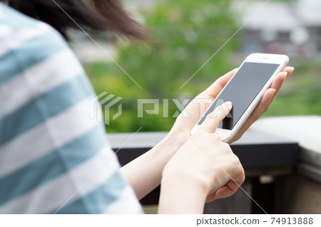 Woman operating a smartphone 74913888