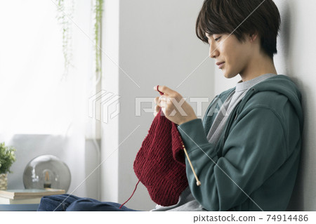 Profile of a young man knitting Profile of a young man knitting 74914486