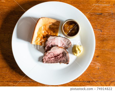 served Roast Beef and pudding on white plate 74914822