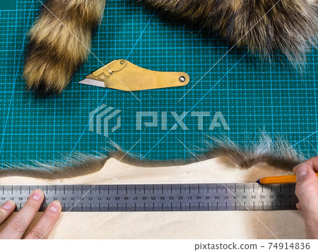 craftsman draws pattern on pelt with pen and ruler craftsman draws pattern on pelt with pen and ruler 74914836