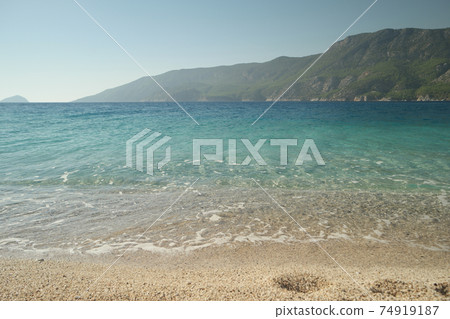 Sandy beach with crystal clear sea water. Sandy beach with crystal clear sea water. 74919187