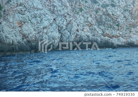 Rocky shore and blue calm sea. 74919330
