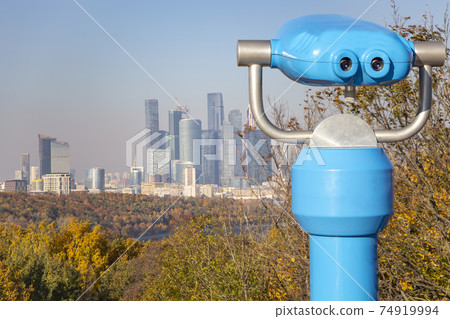 Touristic telescope viewer (binoculars) and View of the city and the complex of skyscrapers Moscow city from Sparrow Hills or Vorobyovy Gory observation (viewing) platform Touristic telescope viewer (binoculars) and View of the city and the complex of skyscrapers Moscow city from Sparrow Hills or Vorobyovy Gory observation (viewing) platform 74919994