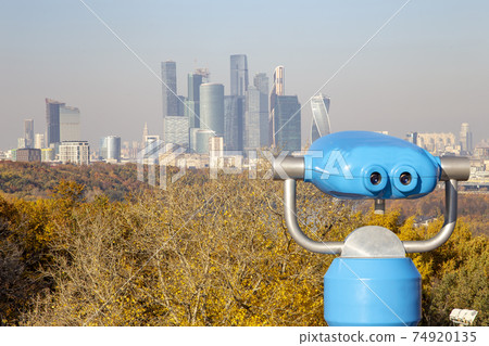 Touristic telescope viewer (binoculars) and view of central Moscow from Sparrow Hills or Vorobyovy Gory observation (viewing) platform 74920135