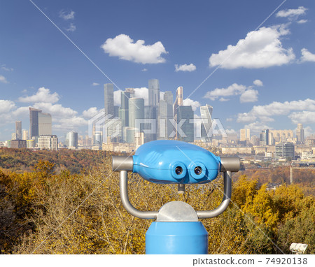 Touristic telescope viewer (binoculars) and view of central Moscow from Sparrow Hills or Vorobyovy Gory observation (viewing) platform 74920138