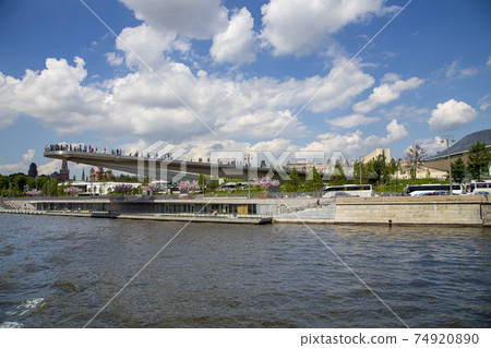 Floating bridge of Zaryadye park on Moskvoretskaya Embankment of Moskva River in Moscow, Russia. Shooting from a tourist pleasure boat Floating bridge of Zaryadye park on Moskvoretskaya Embankment of Moskva River in Moscow, Russia. Shooting from a tourist pleasure boat 74920890
