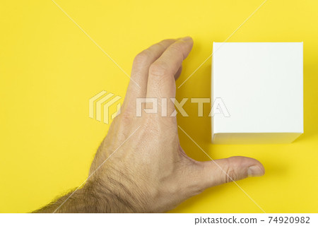 Mens hand takes white cardboard box. Man wants to take box. Copy space. Mock up. Mens hand takes white cardboard box. Man wants to take box. Copy space. Mock up. 74920982