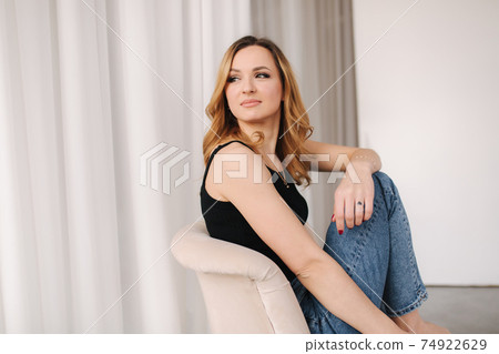 Photo of young woman in studio. Female in demin and black t-shirt Photo of young woman in studio. Female in demin and black t-shirt 74922629