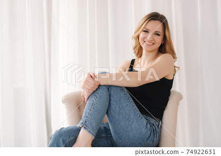 Photo of young woman in studio. Female in demin and black t-shirt 74922631