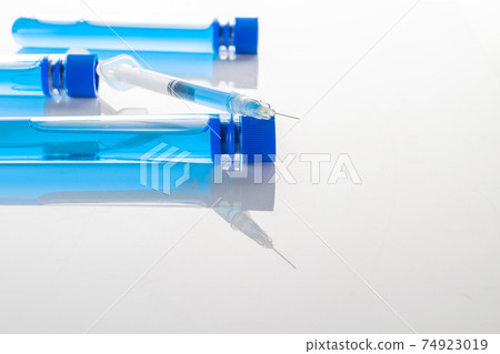 Vaccine vial. Medical syringe with needle for protection flu virus and coronavirus. Covid inoculation on white. Close up vaccine vial dose flu shot drug needle syringe. 74923019