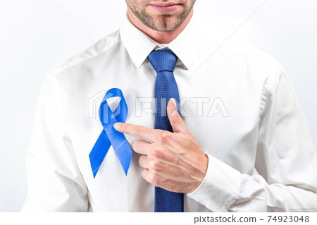 Cancer men. Awareness prostate of health in November. Hipster men in bright shirt, cyan tie with blue ribbon in hands on white background. Supporting people living and illness. Cancer men. Awareness prostate of health in November. Hipster men in bright shirt, cyan tie with blue ribbon in hands on white background. Supporting people living and illness. 74923048