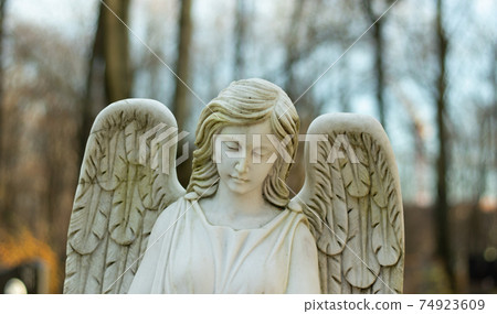 Marble white female angel with wings with blurry background Marble white female angel with wings with blurry background 74923609