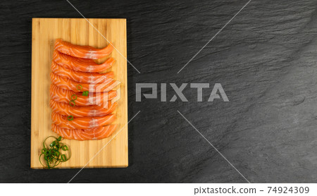 Slices of Raw Salmon Fillet on Black Background Mockup Top View 74924309