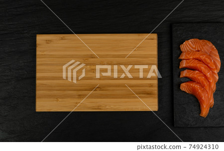 Slices of Raw Salmon Fillet on Black Background Mockup Top View 74924310