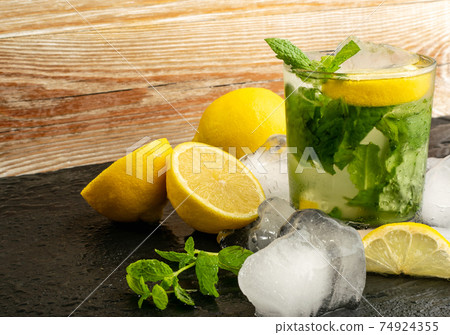 Infused lemon water with ice cubes closeup Infused lemon water with ice cubes closeup 74924355