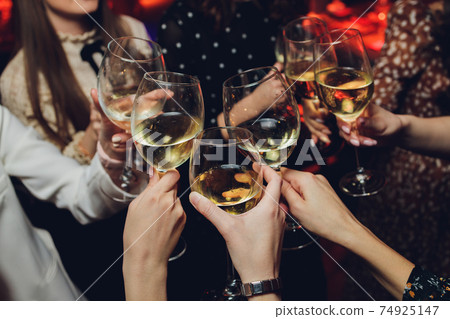 Clinking glasses with alcohol and toasting, party. 74925147
