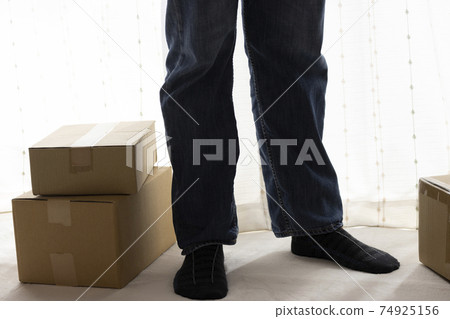 Stacked cardboard and man's feet. Moving image Stacked cardboard and man's feet. Moving image 74925156