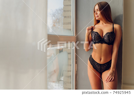 Pretty smiling girl underwear portrait near the window. 74925945
