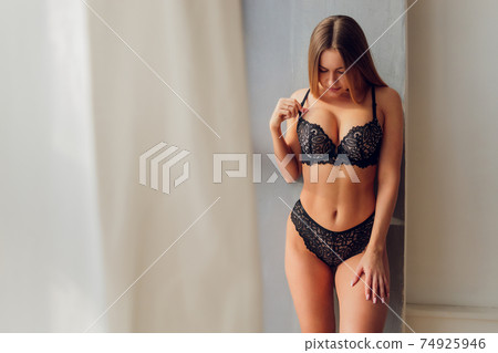 Pretty smiling girl underwear portrait near the window. 74925946