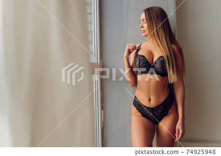 Pretty smiling girl underwear portrait near the window. 74925948