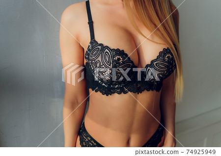 Suntanned beautiful harmonous well-groomed body of the young girl in a brassiere, close up. 74925949