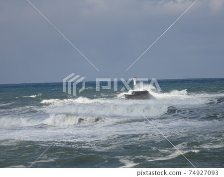 日本海的冬季風景,在那裡您可以看到海浪用燈塔撞擊碼頭 日本海的冬季風景,在那裡您可以看到海浪用燈塔撞擊碼頭 74927093