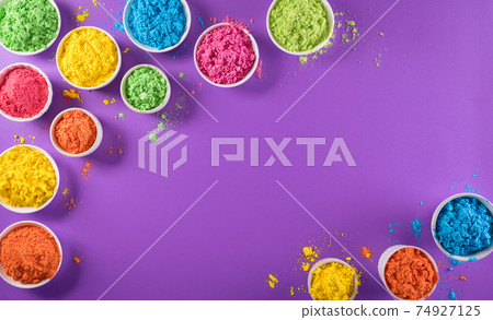 Happy holi festival decoration.Top view of colorful holi powder on purple  background with copy space for text. 74927125