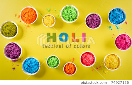 Happy holi festival decoration.Top view of colorful holi powder on yellow  background with copy space for text. 74927126