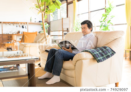 Nesting / House time Senior man reading a magazine Nesting / House time Senior man reading a magazine 74929097