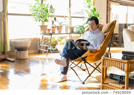 Nesting / House time Senior man reading a magazine Nesting / House time Senior man reading a magazine 74929099