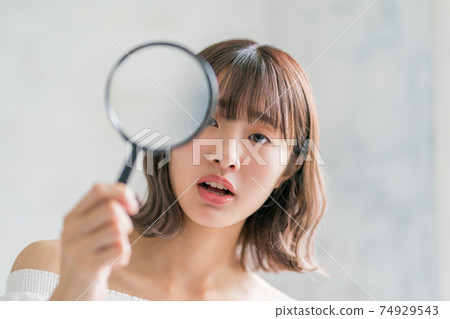 Late teenage girls and magnifying glass 74929543