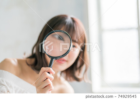 Late teenage girls and magnifying glass 74929545
