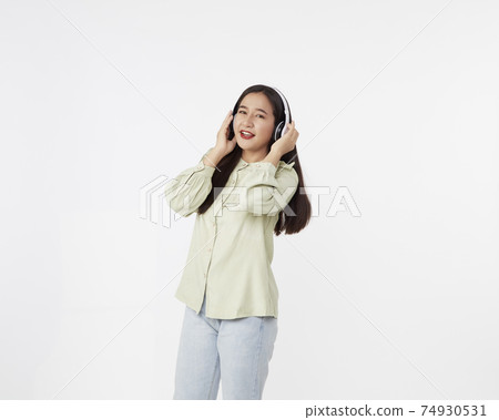 Joyful beautiful young Asian girl in headphones 74930531