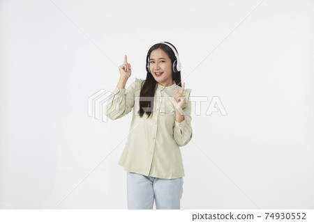 Joyful beautiful young Asian girl in headphones Joyful beautiful young Asian girl in headphones 74930552