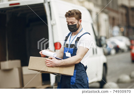 Delivery man with package outdoors 74930970