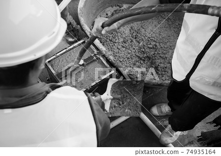 Pouring Concrete mix into mold and using concrete vibrator Pouring Concrete mix into mold and using concrete vibrator 74935164