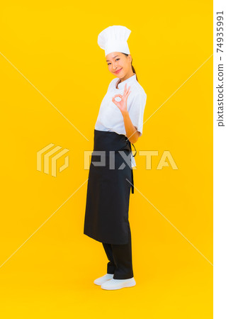 Portrait beautiful young asian woman in chef or cook uniform with hat Portrait beautiful young asian woman in chef or cook uniform with hat 74935991