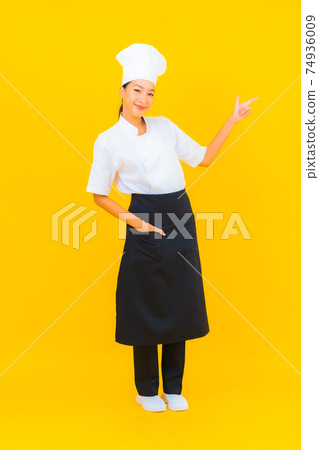 Portrait beautiful young asian woman in chef or cook uniform with hat Portrait beautiful young asian woman in chef or cook uniform with hat 74936009