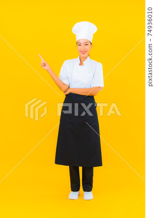 Portrait beautiful young asian woman in chef or cook uniform with hat Portrait beautiful young asian woman in chef or cook uniform with hat 74936010
