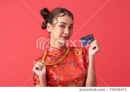 beautiful Asian woman wearing traditional cheongsam qipao dress showing credit card beautiful Asian woman wearing traditional cheongsam qipao dress showing credit card 74936471