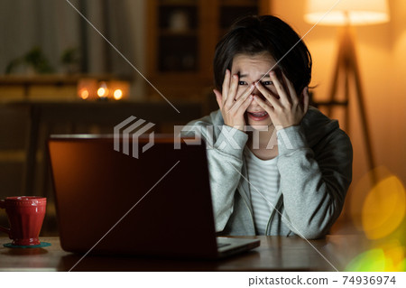 一名年輕女子在午夜在客廳裡觀看恐怖片 74936974