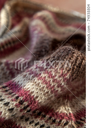 fragment of warm striped raglan sweater on pink concrete background. 74938804