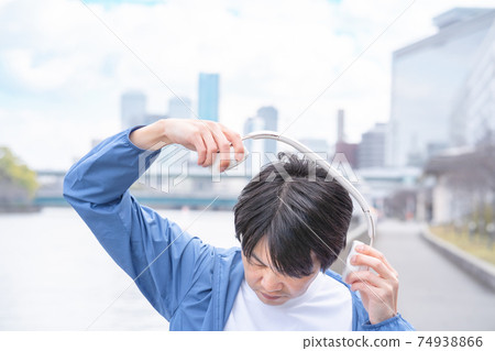 Image of a man enjoying music content in the city Image of a man enjoying music content in the city 74938866