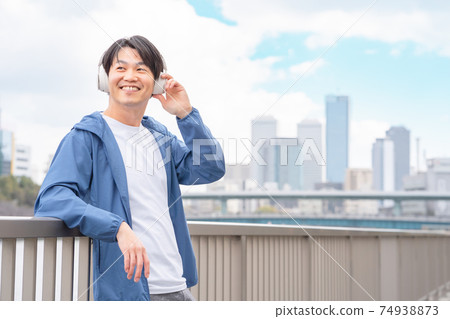 Image of a man enjoying music in the city 74938873