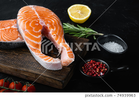 Slice of red fish trout with herbs, over black background Slice of red fish trout with herbs, over black background 74939963