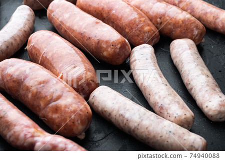 Assorted fresh raw pork, beef and chicken sausages, on black background 74940088